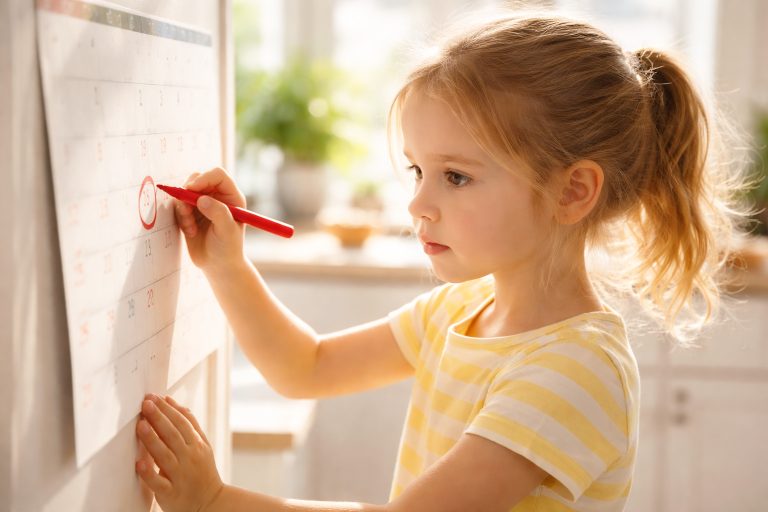 Kind markiert selbstständig Kalender